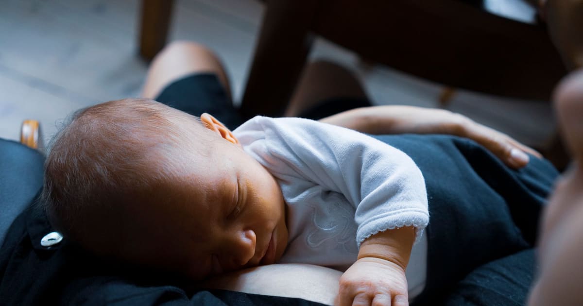 Mãe a descansar com o bebé ao colo