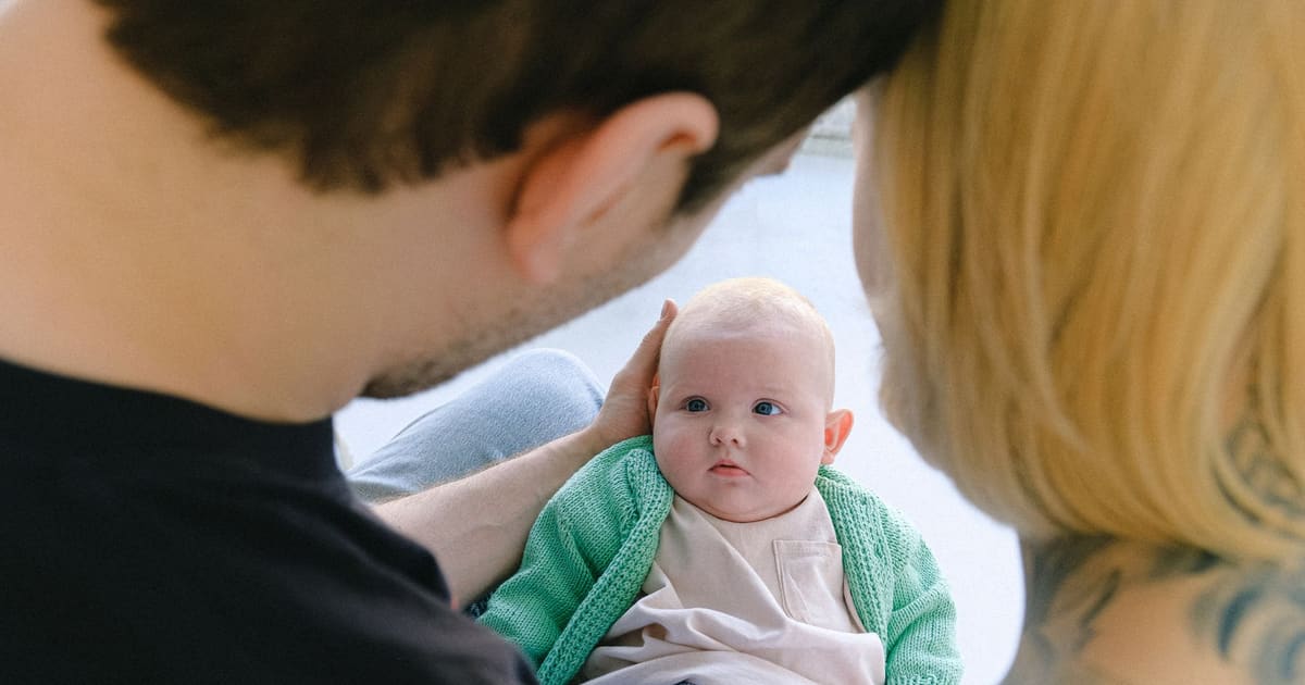 Mãe e pai com o bebé recém-nascido em casa